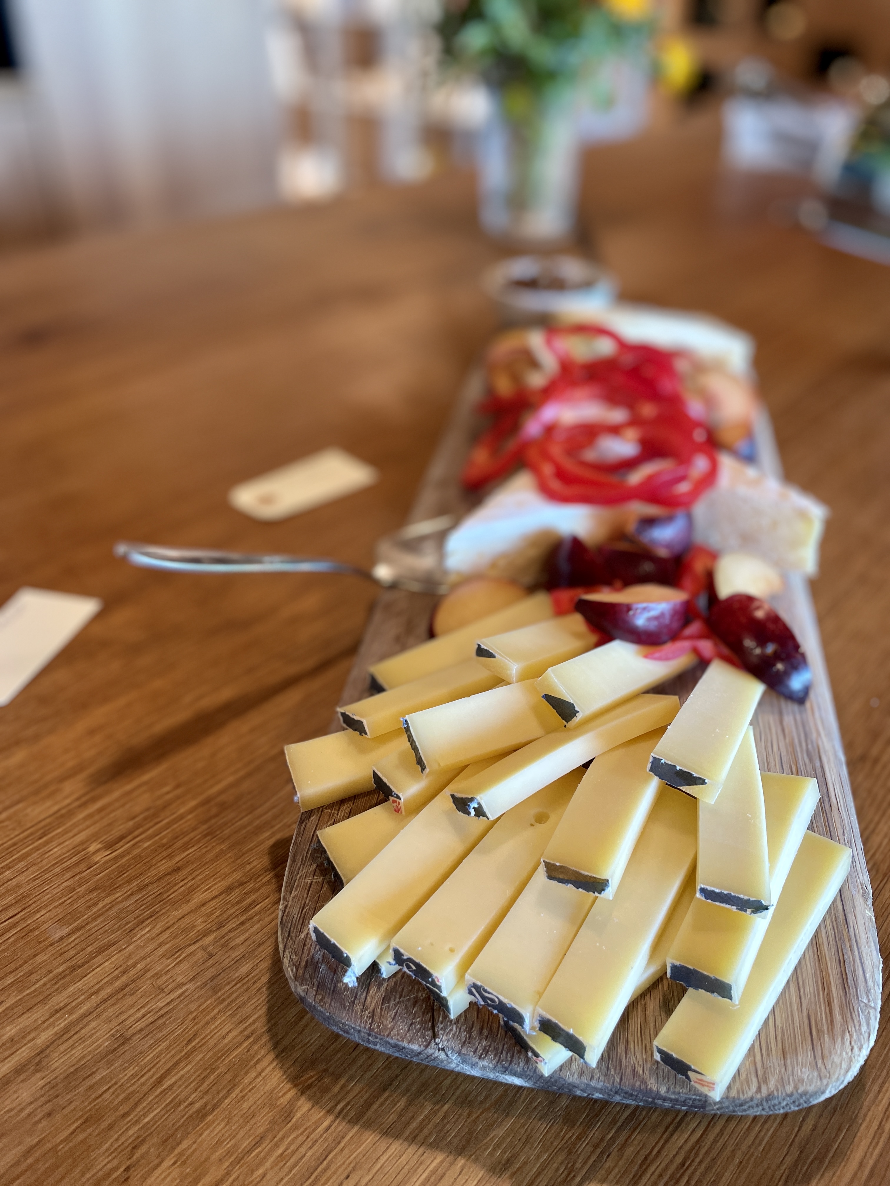 oste med tilbehør på serveringsbræt i træ